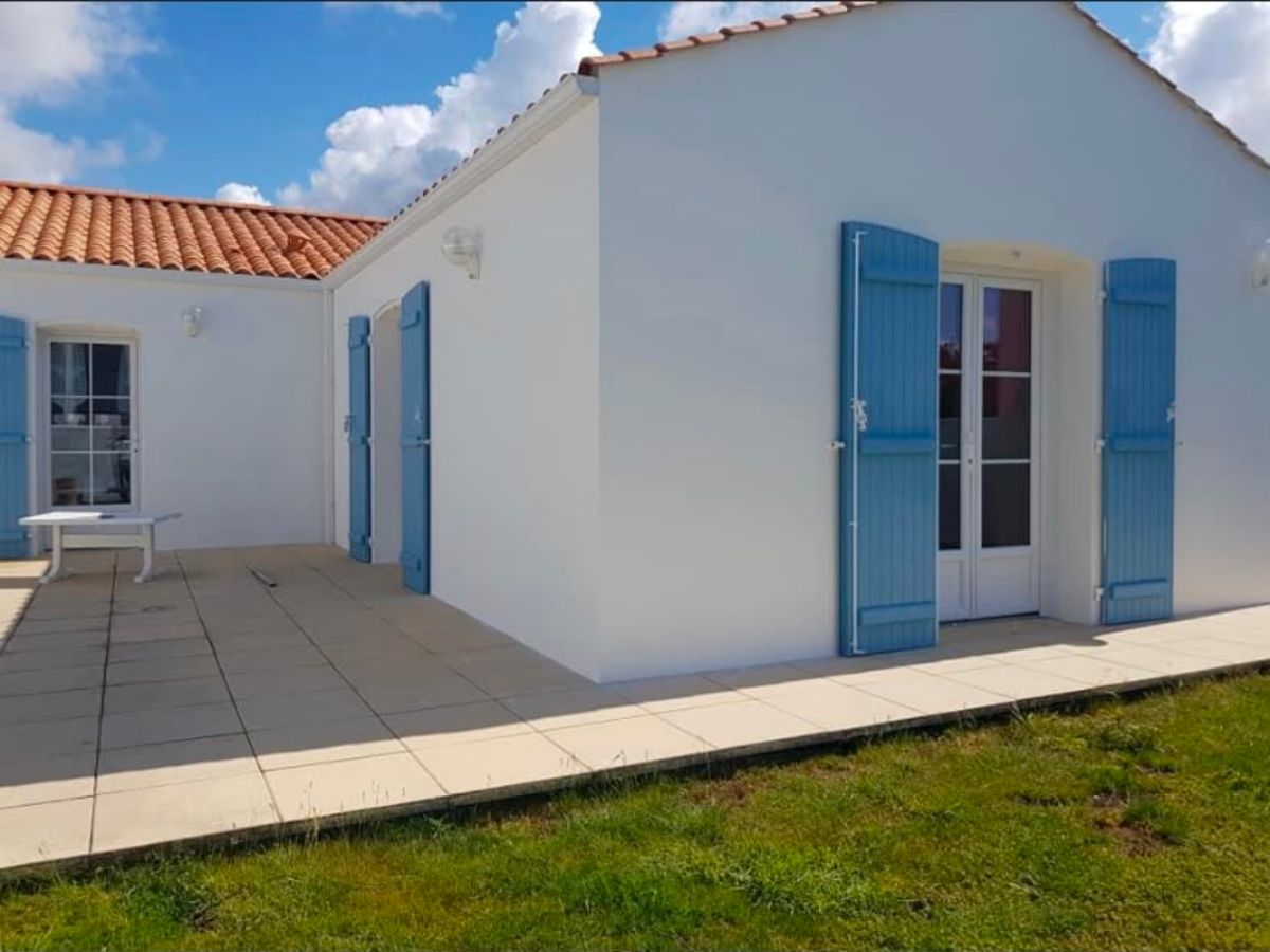 Façade blanche et volets bleus après travaux