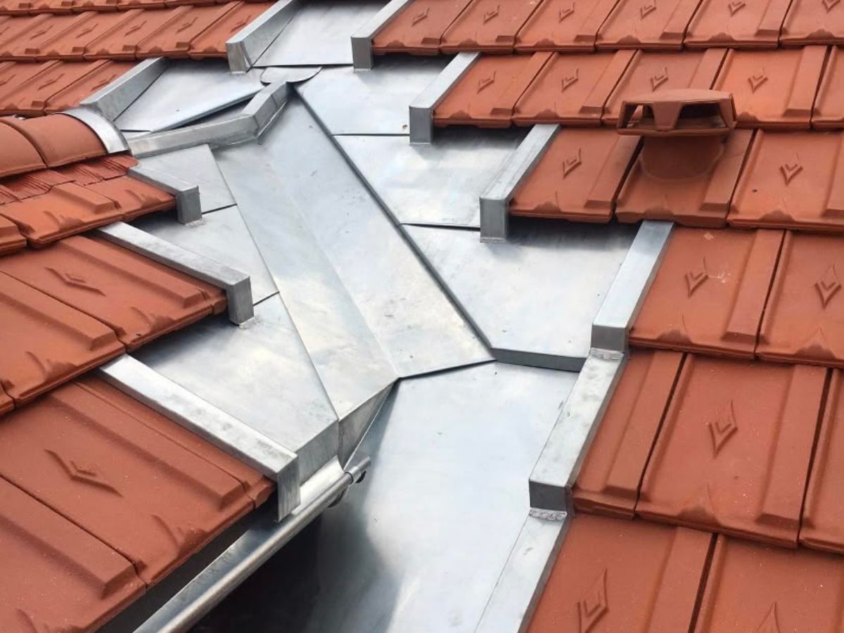Détail d'une noue en zinc neuve sur une couverture en tuile